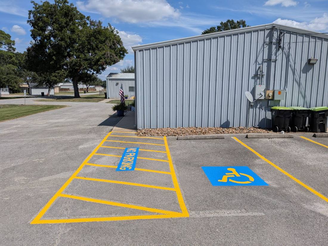 The same lot after striping, with an ADA stall and a hatched access aisle marked NO PARKING