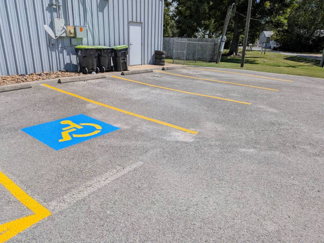 Freshly striped parking stall row with a blue and yellow ADA accessible symbol