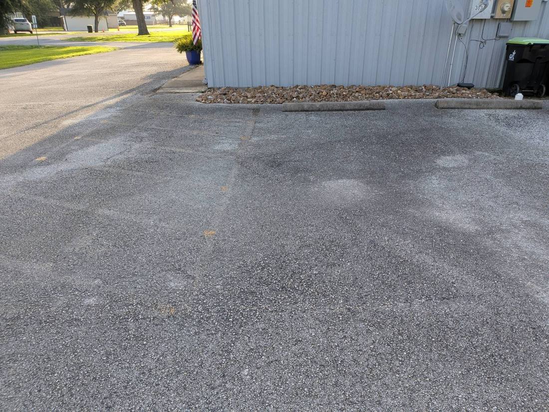 Blank asphalt parking lot with no stall lines at all before striping
